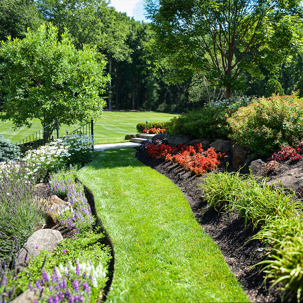 Thick green turf and flower beds on a maintained Bucks County property