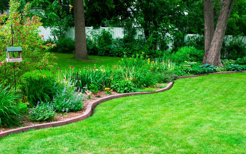 Premium brass landscape lighting fixtures illuminating a manicured garden bed