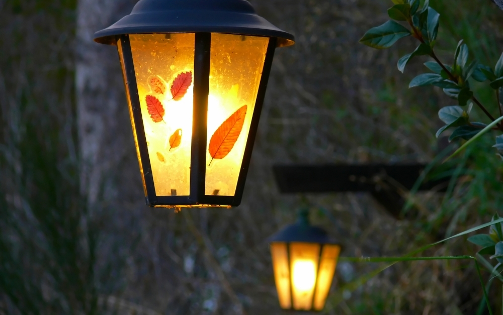 Professional low-voltage permanent outdoor lighting casting a warm, balanced architectural wash on stone veneer siding